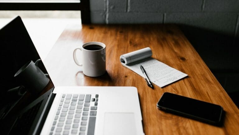 Desk with computer, coffee, and checklist