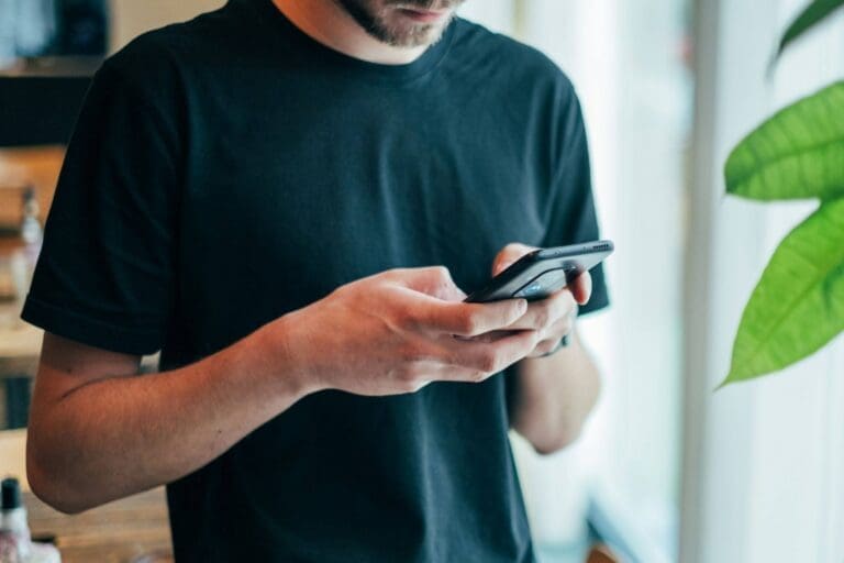 A man texting on his phone in an office